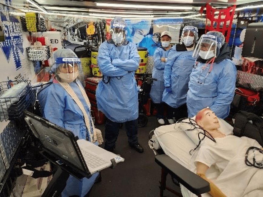 A group of doctors in blue gowns and masks.