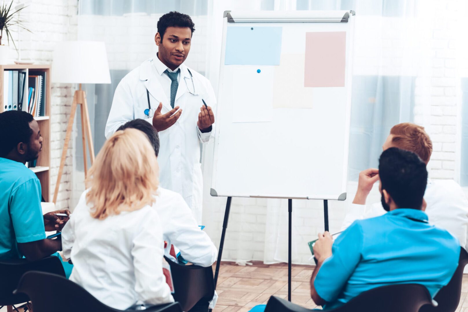Indian Doctor Shares Experience With Colleagues. Paper Desk Information. Professional Medical Consultation. Multinational Medician Meeting. Teamwork Connection. Clinician Team Group.